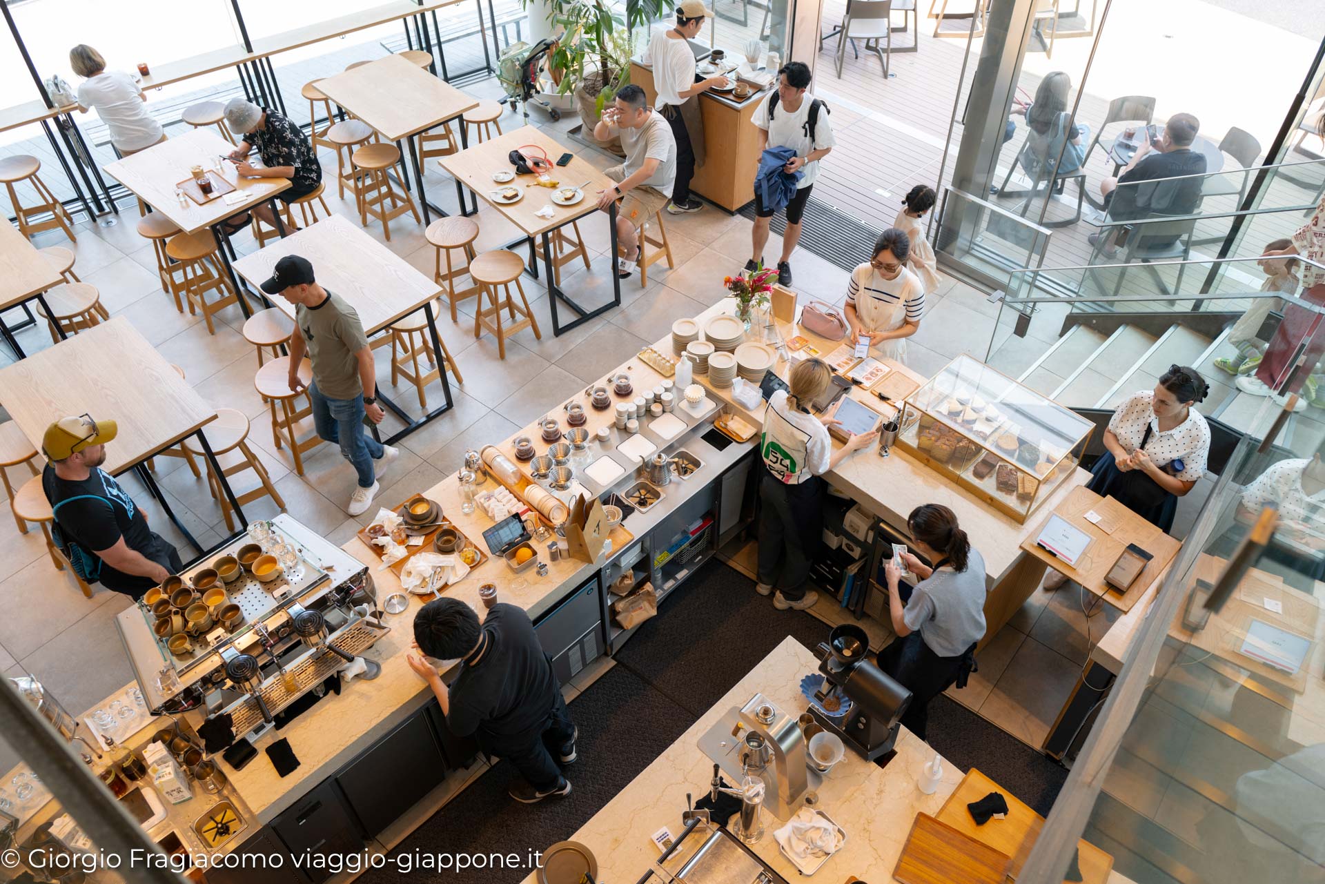 Caffè moderno in Giappone, con clienti che gustano bevande e dessert in un ambiente luminoso e accogliente.