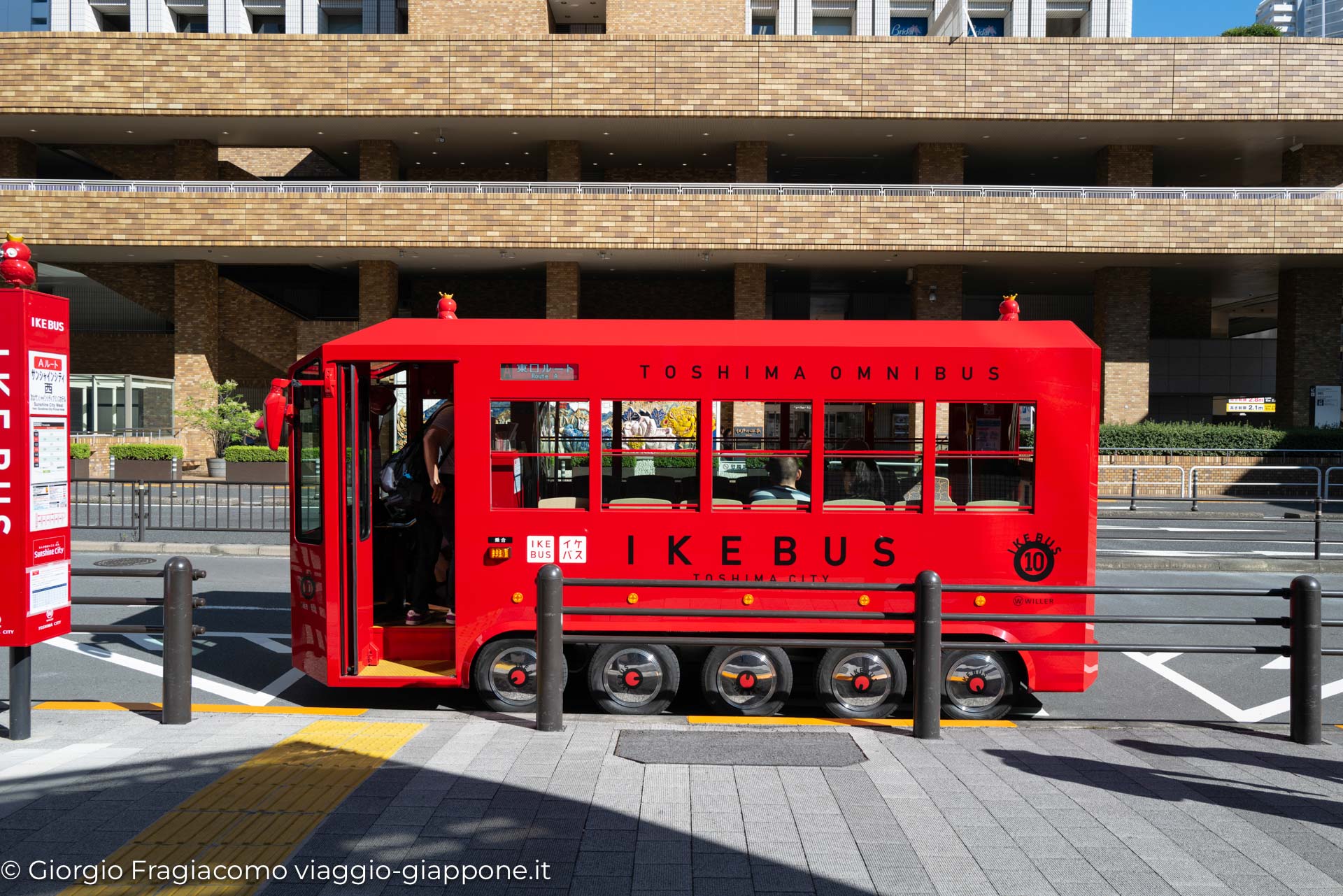 Autobus rosso Ikebus a Toshima, Giappone, in attesa di passeggeri in una giornata soleggiata.