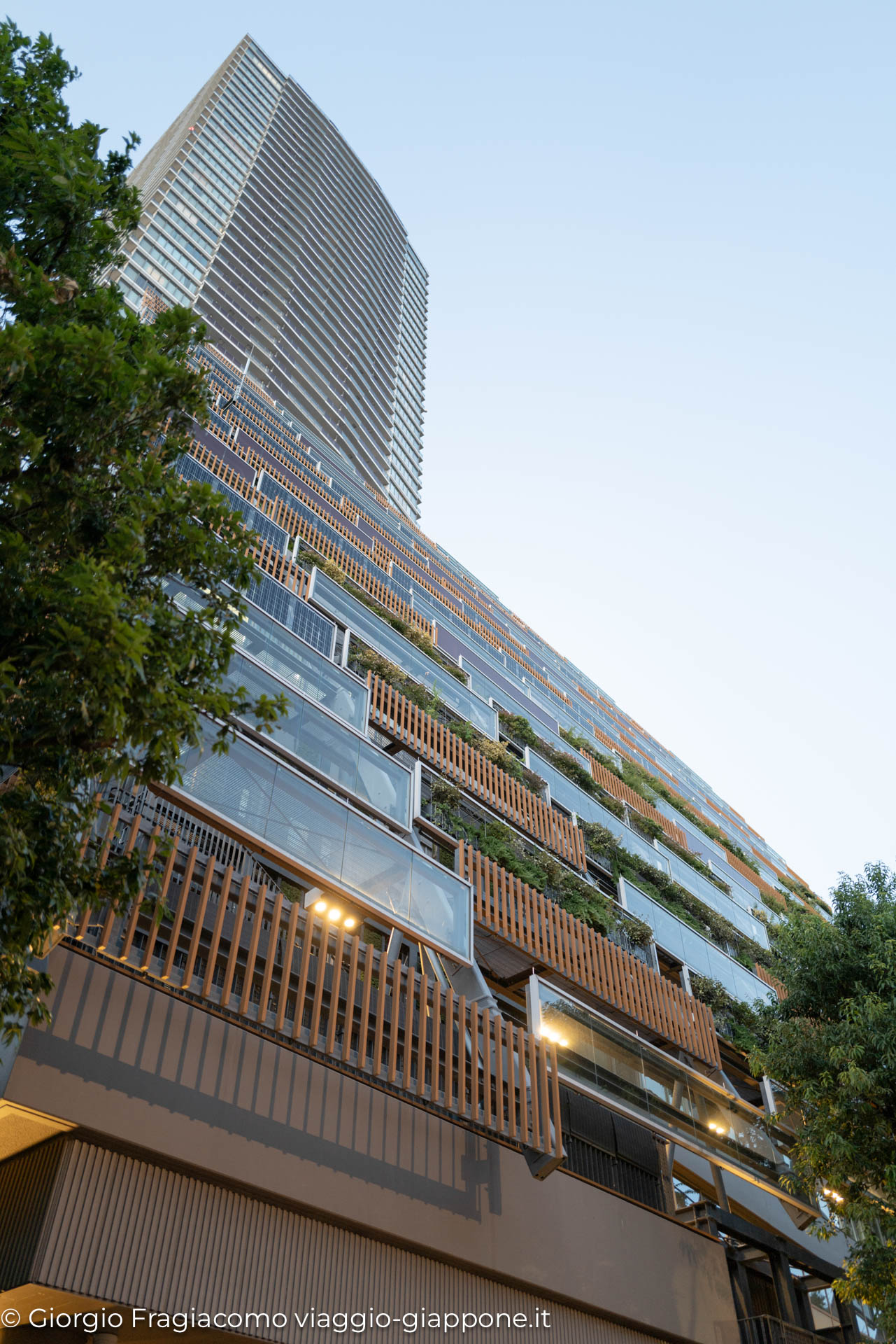 Edificio moderno in Giappone, caratterizzato da balconi verdi e design sostenibile. Architettura innovativa e urbana.